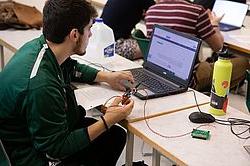 Computer Engineering student programming a printed circuit board.